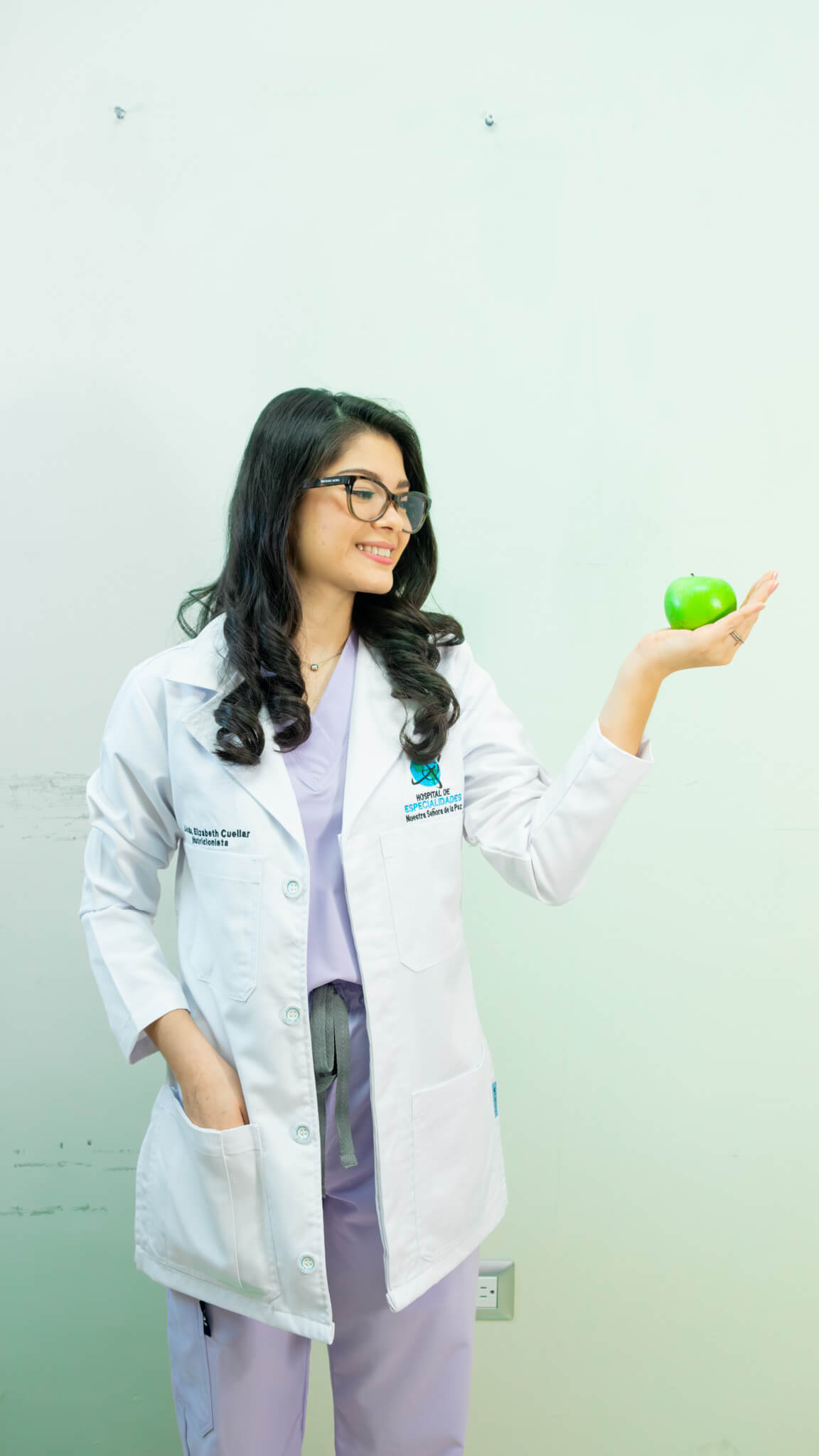 Nutricionista Elizabeth Cuellar en San Miguel El Salvador en consulta presencial, sosteniendo una manzana verde como símbolo de alimentación saludable